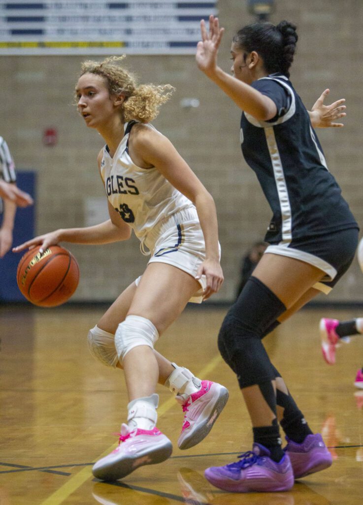 Arlington’s Samara Morrow tries to maneuver around a Lynnwood player during the game on Monday, Dec. 11, 2023 in Arlington, Washington. (Olivia Vanni / The Herald)
