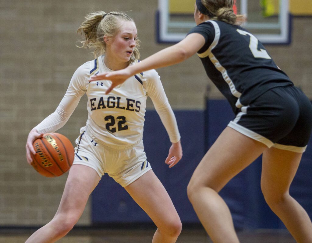 Arlington’s Kierra Reese dribbles by Lynnwood’s Kaya Lorenz during the game on Monday in Arlington. (Olivia Vanni / The Herald)
