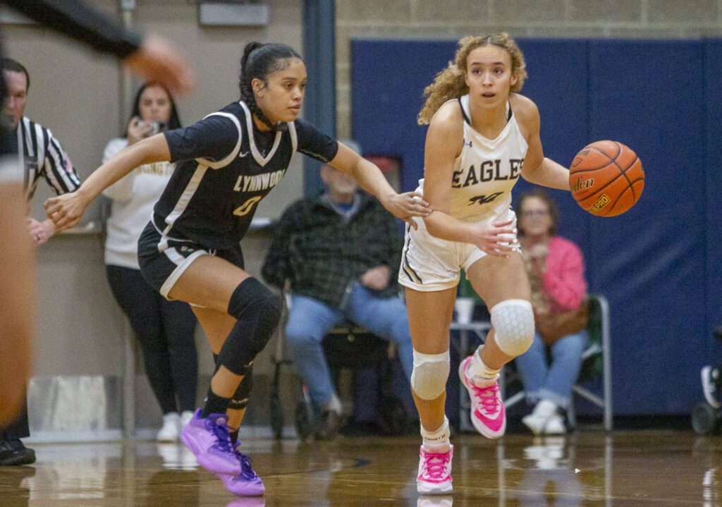 Arlington’s Samara Morrow tries to get around Lynnwood’s Aniya Hooker after rebounding the ball during the game on Monday, Dec. 11, 2023 in Arlington, Washington. (Olivia Vanni / The Herald)
