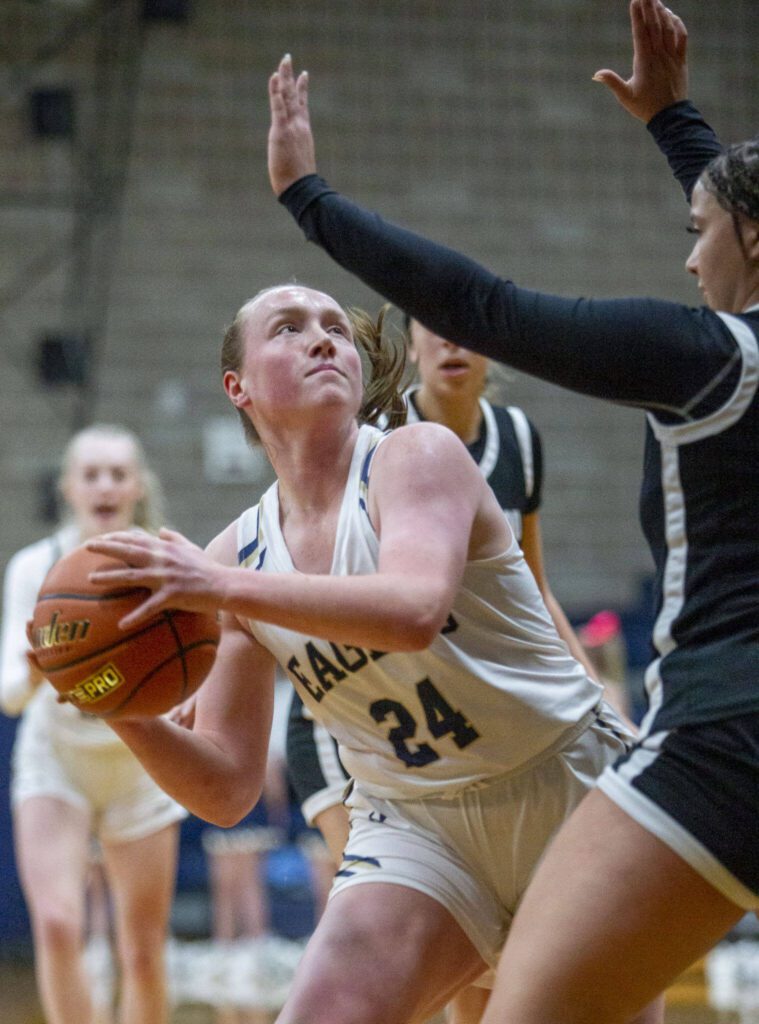 Arlington’s Katie Snow looks for an opening to shoot a layup during the game against Lynnwood on Monday, Dec. 11, 2023 in Arlington, Washington. (Olivia Vanni / The Herald)
