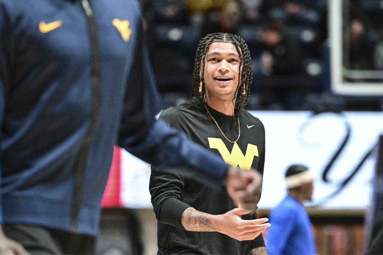 West Virginia Guard RaeQuan Battle looks on prior to the game against the Pittsburgh Panthers on Dec. 6, 2023, in Morgantown, WV. Battle, formerly of Montana State, has yet to play this season. College athletes like Battle who were denied the chance to play immediately after transferring a second time can return to competition, for now, after a federal judge issued a 14-day temporary restraining order Wednesday, Dec. 13, 2023, against the NCAA. (William Wotring/The Dominion-Post via AP)