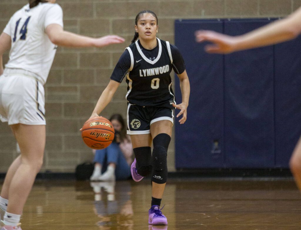 Lynnwood’s Aniya Hooker takes the ball down the court during a game against Arlington on Dec. 11 in Arlington. (Olivia Vanni / The Herald)
