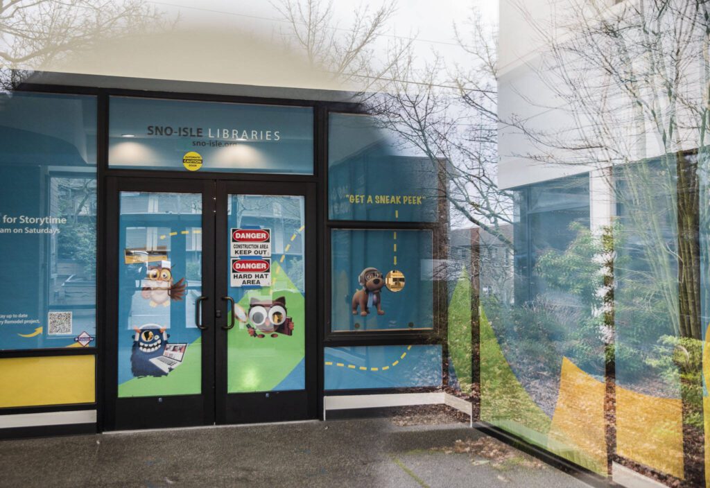 Signs of construction and offering people a “sneak peek” are visible outside of the soon to be reopened Edmonds Library on Tuesday, Dec. 19, 2023 in Edmonds, Washington. (Olivia Vanni / The Herald)
