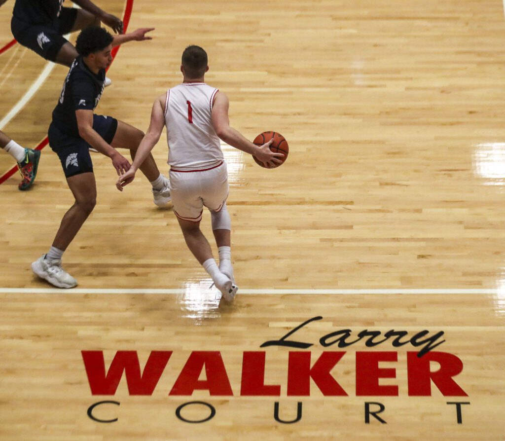 Everett Community College’s Ethan Martin (1) dribbles near his grandfather’s name during a game against Tacoma on Dec. 9 at Everett Community College in Everett. (Annie Barker / The Herald)
