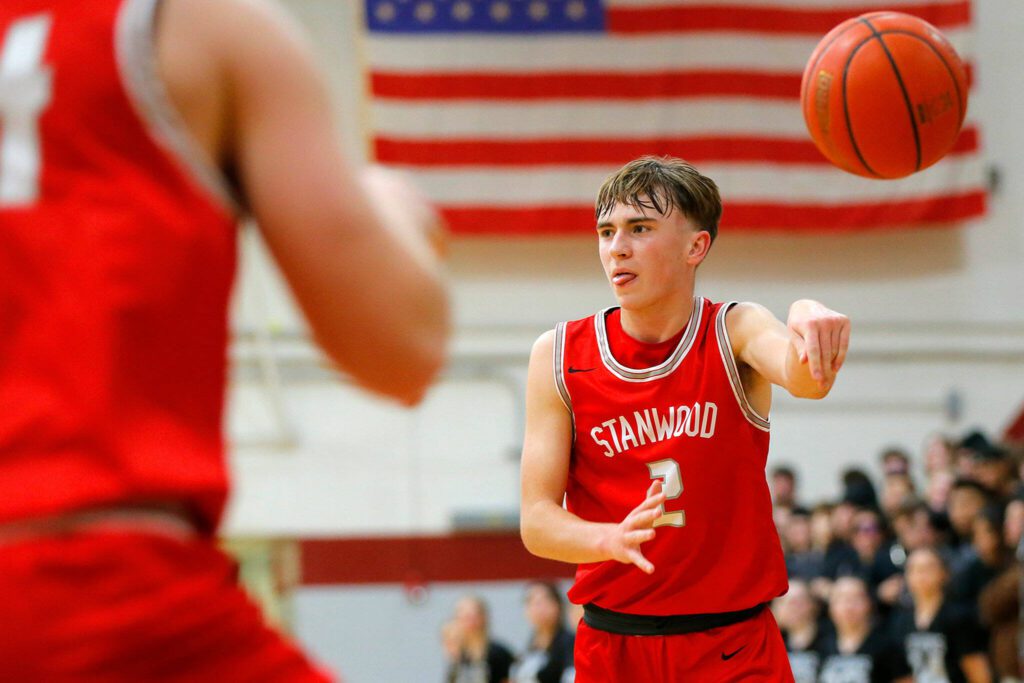Stanwood’s John Floyd makes a no-look pass to a teammate against Cascade on Dec. 8, 2022, at Cascade High School in Everett. (Ryan Berry / The Herald)
