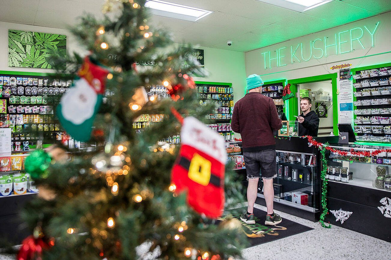 Matt Folmsbee, right, helps a customer at The Kushery on Friday, Dec. 15, 2023 in Everett, Washington. (Olivia Vanni / The Herald)