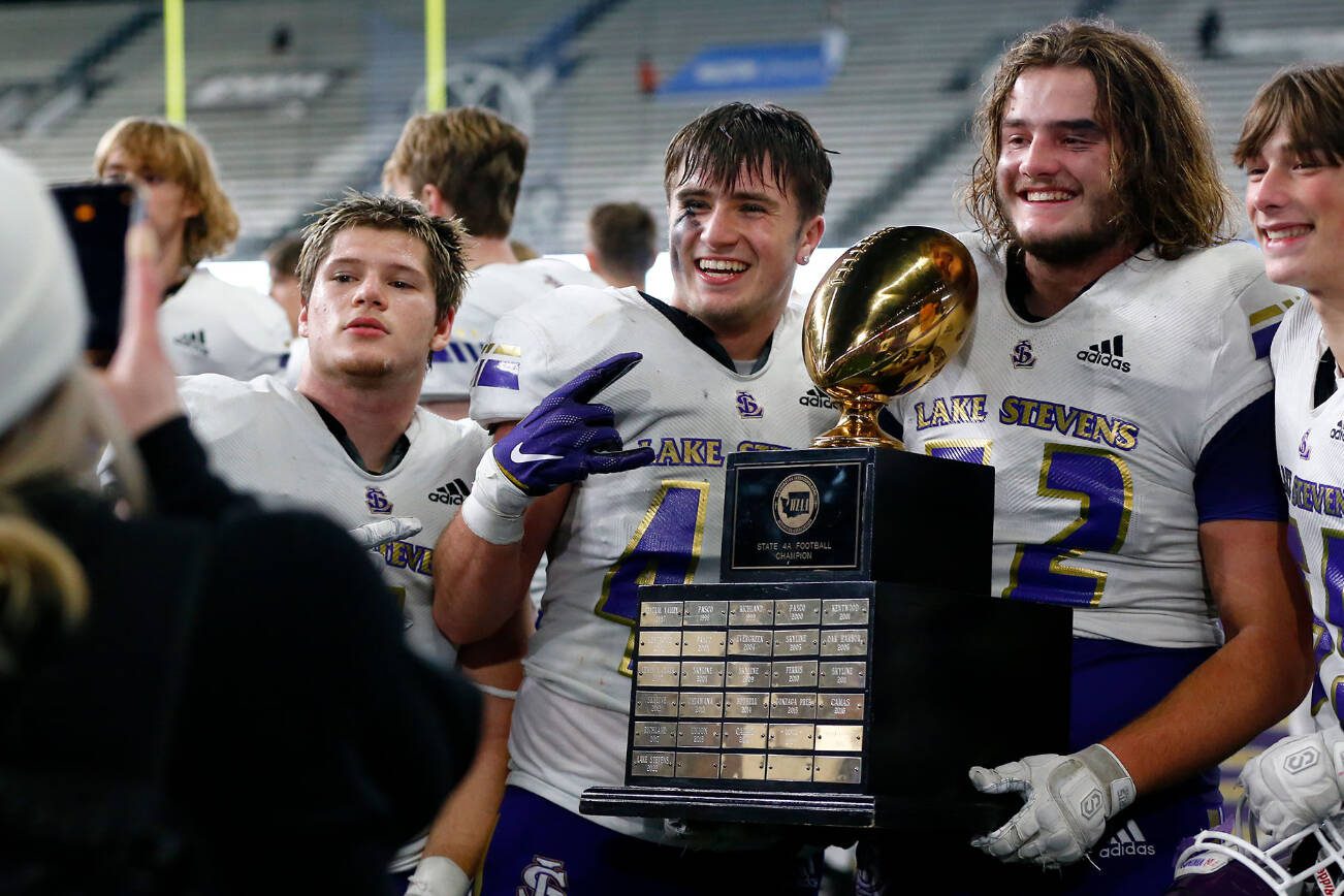 Lake Stevens players take photos with the championship trophy after their win over Graham-Kapowsin during the WIAA 4A Football State Championship on Saturday, Dec. 2, 2023, at Husky Stadium in Seattle, Washington. (Ryan Berry / The Herald)