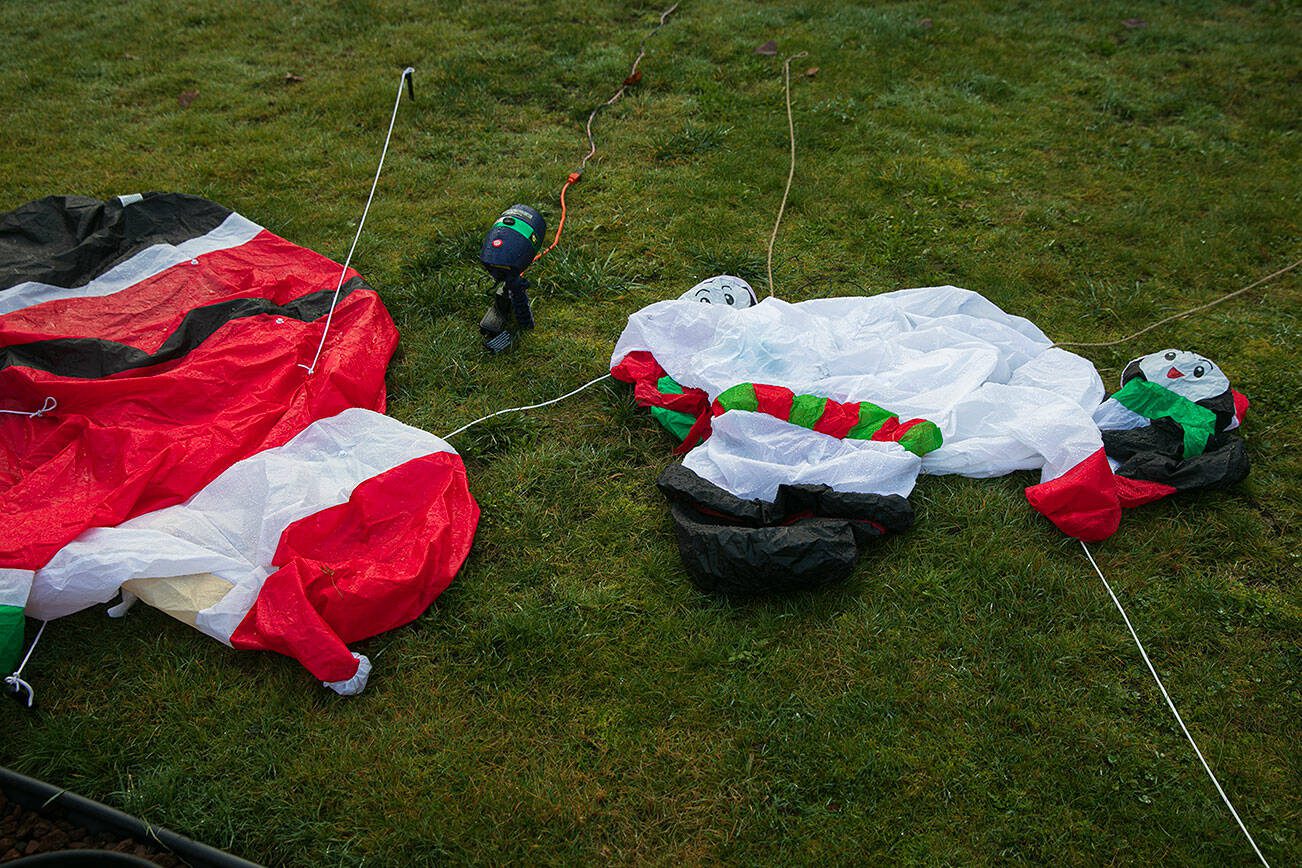 Santa Claus and Frosty the Snowman, photographed on Thursday, Dec. 21, 2023, in the Westmont neighborhood of Everett, Washington, are feeling a little deflated by the news of a gray, rainy Christmas. (Ryan Berry / The Herald)