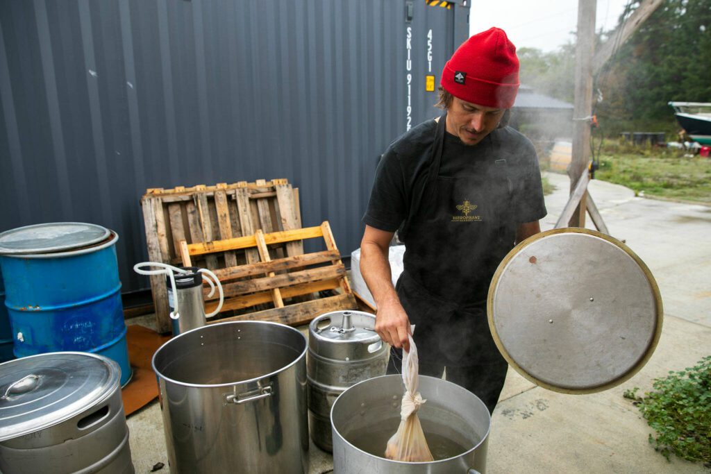 Kyle Taylor, a longtime friend of owners Michelle Scandalis and Jeremy Kyncl, works on a non-alcoholic switchel at Hierophant Meadery on Wednesday, Oct. 4, 2023, in Freeland, Washington. (Ryan Berry / The Herald)
