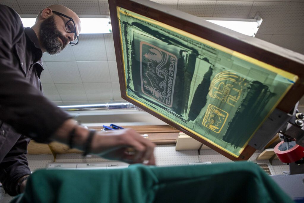 Jonathan Carpenter Eells prints a shirt at elSage in Mount Vernon, Washington, on Thursday, Dec. 14, 2023. (Annie Barker / The Herald)

