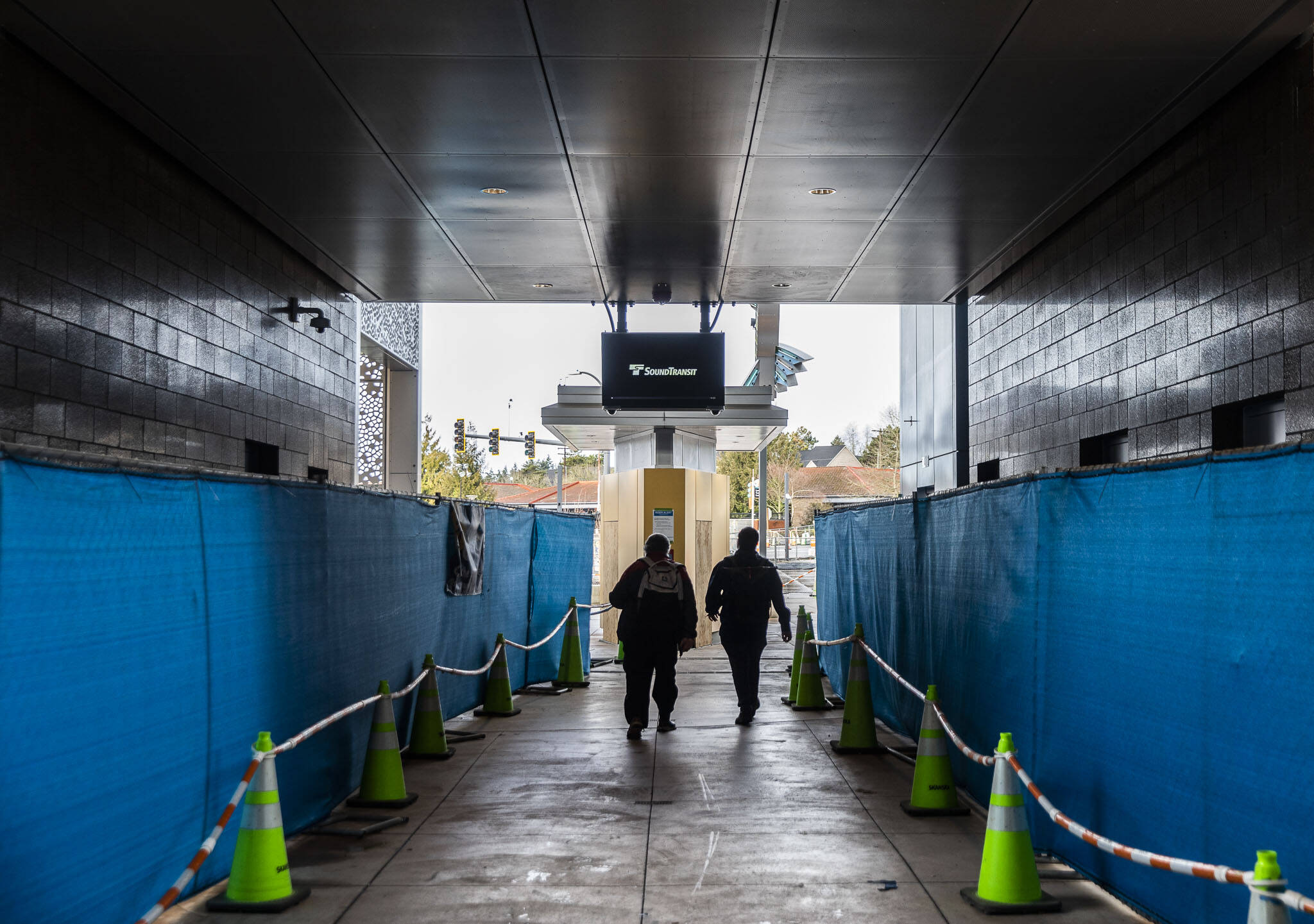 People walk underneath Sound Transit’s Link Lynnwood City Center Station currently under construction on Thursday, Dec. 28, 2023 in Lynnwood, Washington. (Olivia Vanni / The Herald)