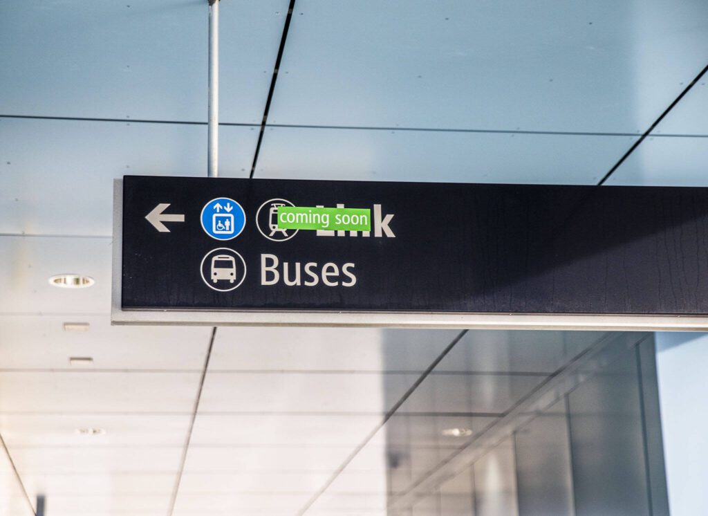 A sign directing people to Sound Transit’s Link Lynnwood City Center Station is covered by a “coming soon” sticker on Thursday, Dec. 28, 2023 in Lynnwood, Washington. (Olivia Vanni / The Herald)
