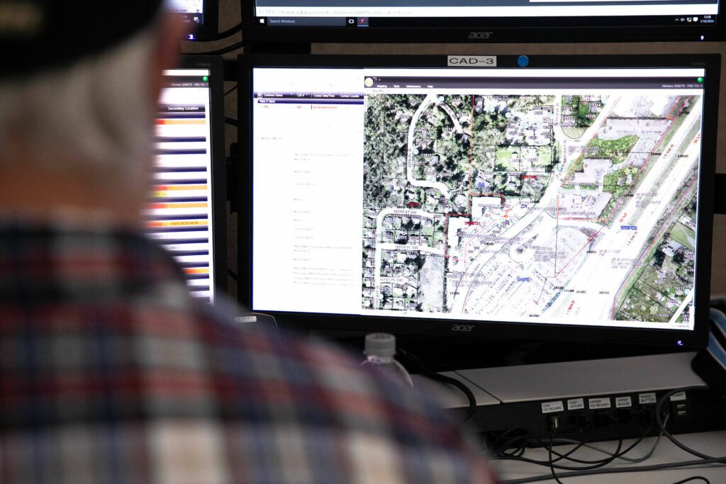 Dispatcher Joe Winters, who has 31 years of experience fielding 911 calls between stints in Marysville and Everett, has a map pulled up while taking calls at the Snohomish County 911 dispatch center Thursday, Jan. 18, 2024, in Everett, Washington. (Ryan Berry / The Herald)
