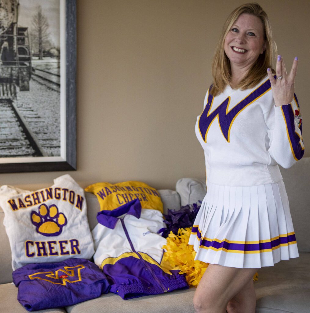 Christy Dahlgren Ely poses with her UW cheerleading uniform she wore at the Jan. 1, 1992 Rose Bowl game. (Annie Barker / The Herald)
