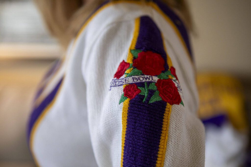 Christy Dahlgren Ely poses with her UW cheerleading uniform she wore at the Jan. 1, 1992 Rose Bowl game. (Annie Barker / The Herald)
