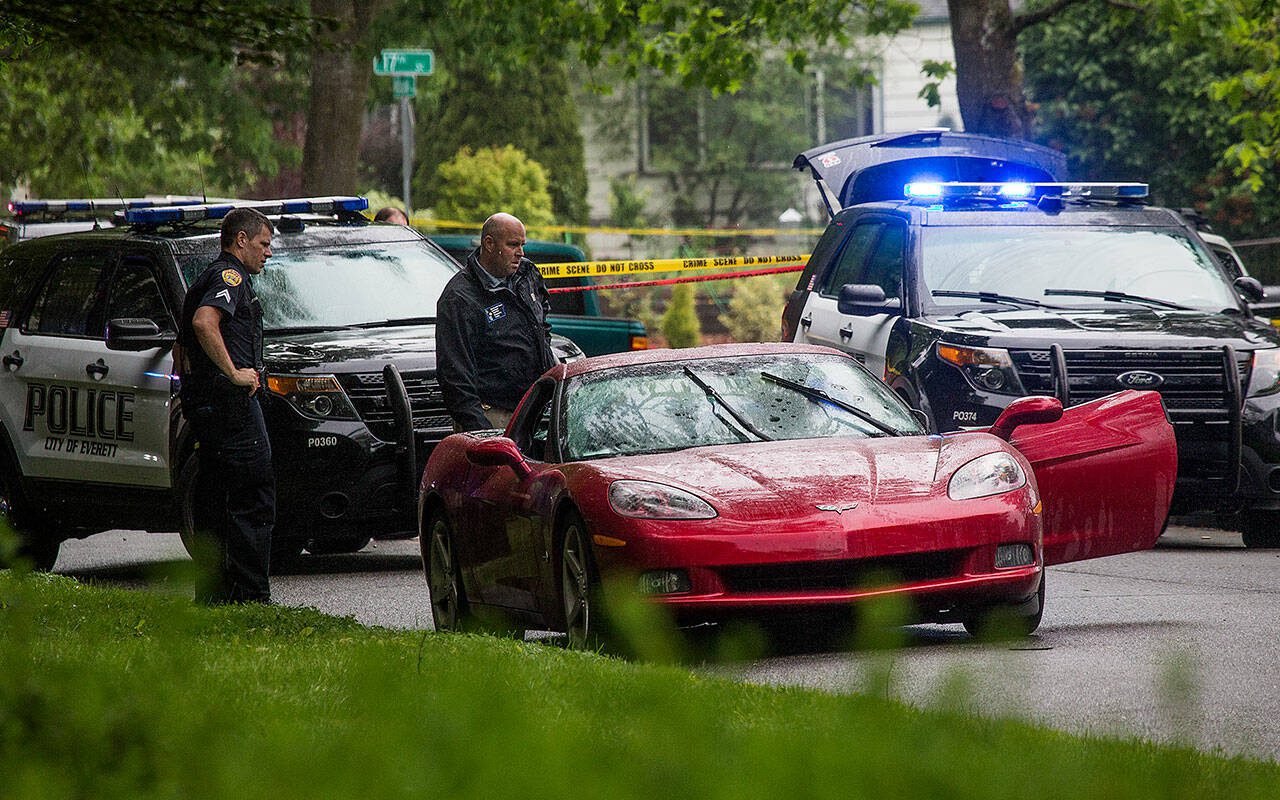 Everett police look over a Chevy Corvette after arresting the suspect in a homicide in the 1700 block of McDougall Avenue on Friday, May 24, 2019 in Everett, Washington. (Andy Bronson / The Herald)