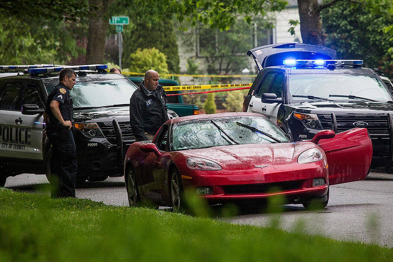 Everett police look over a Chevy Corvette after arresting the suspect in a homicide in the 1700 block of McDougall  Avenue on Friday, May 24, 2019 in Everett, Wash. (Andy Bronson / The Herald)
