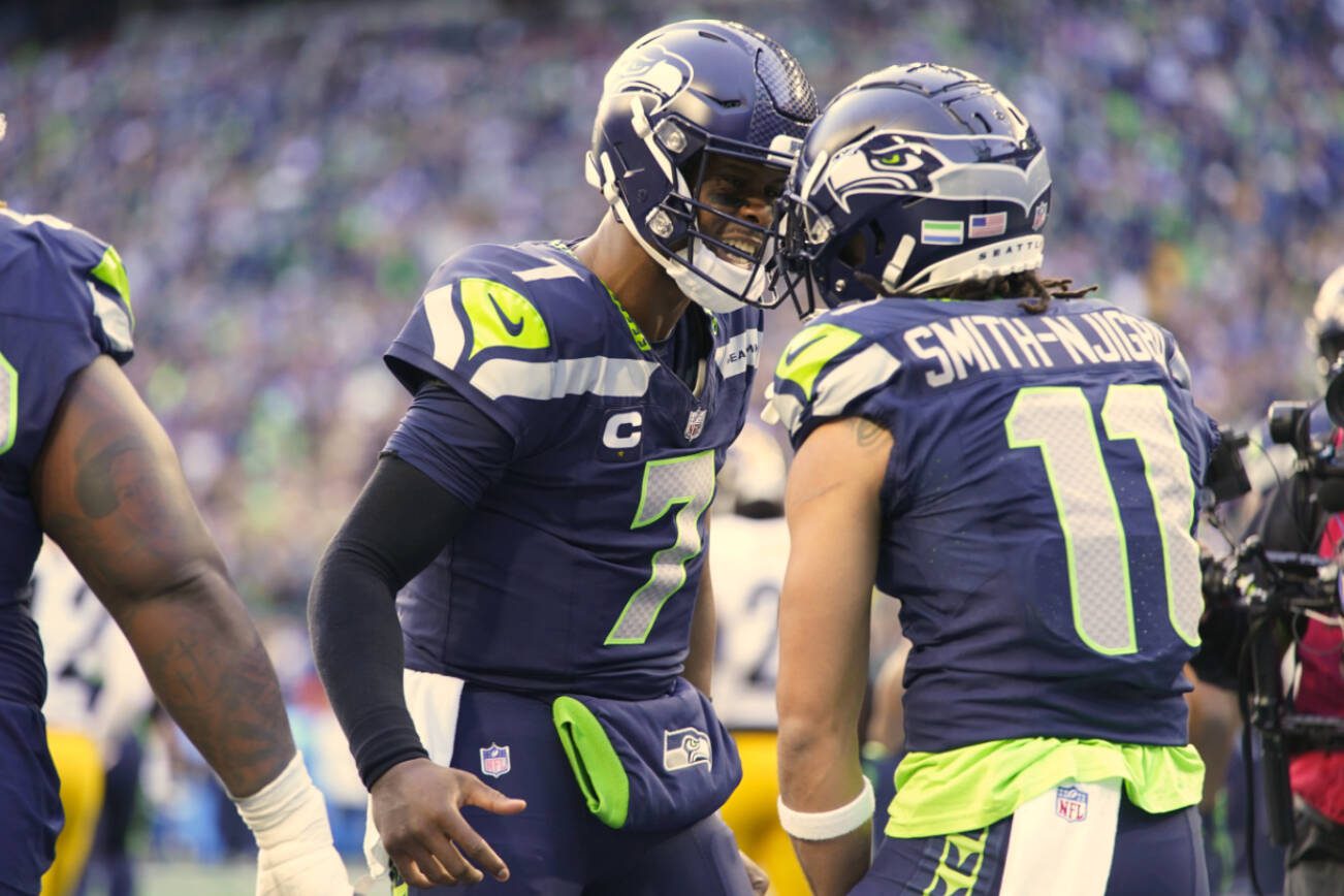 Seattle Seahawks quarterback Geno Smith (7) celebrates with wide receiver Jaxon Smith-Njigba (11) after they combined for a touchdown pass against the Pittsburgh Steelers in the first half of an NFL football game Sunday, Dec. 31, 2023, in Seattle. (AP Photo/Lindsey Wasson)