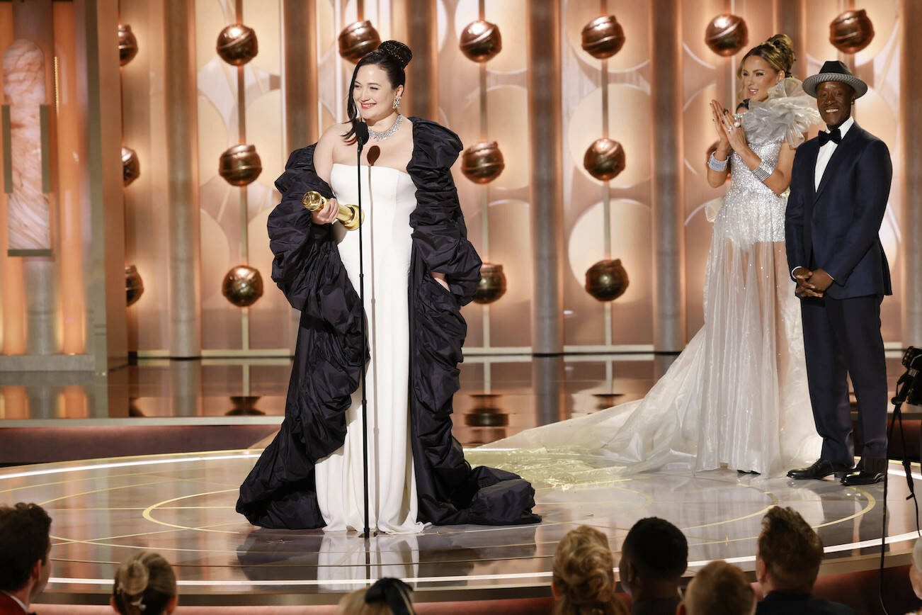 This image released by CBS shows Lily Gladstone, left, as she accepts the award for best female actor in motion picture - drama for her role in "Killers of the Flower Moon" during the 81st Annual Golden Globe Awards in Beverly Hills, Calif., on Sunday, Jan. 7, 2024. Looking on at right are presenters Kate Beckinsale and Don Cheadle. (Sonja Flemming/CBS via AP)