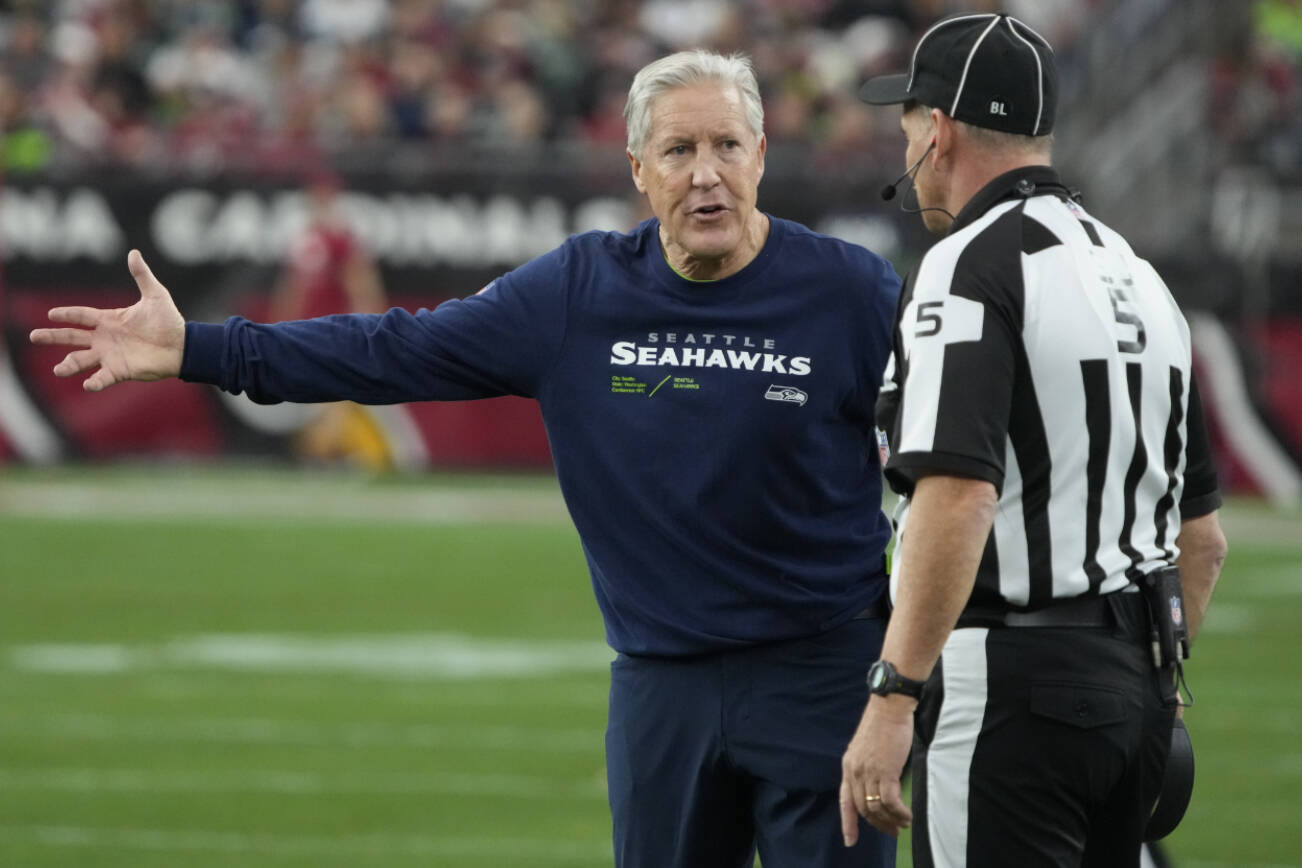 Seattle Seahawks head coach Pete Carroll argues a call with side judge Jim Quirk (5) in the first half of an NFL football game against the Arizona Cardinals Sunday, Jan. 7, 2024, in Glendale, Ariz. (AP Photo/Rick Scuteri)