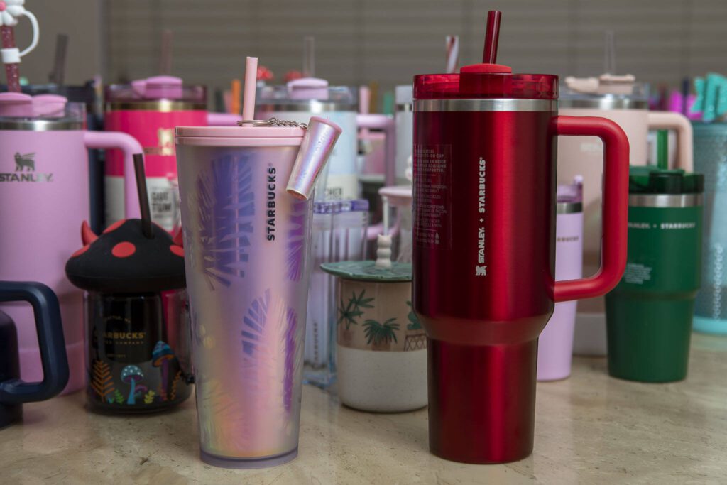 A 2019 Starbucks holiday cup, left, and the red 2023 Starbucks Stanley holiday tumbler, right, are some of Cecilia Garcia’s most sought after bottles in her collection of 200, so far. (Annie Barker / The Herald)
