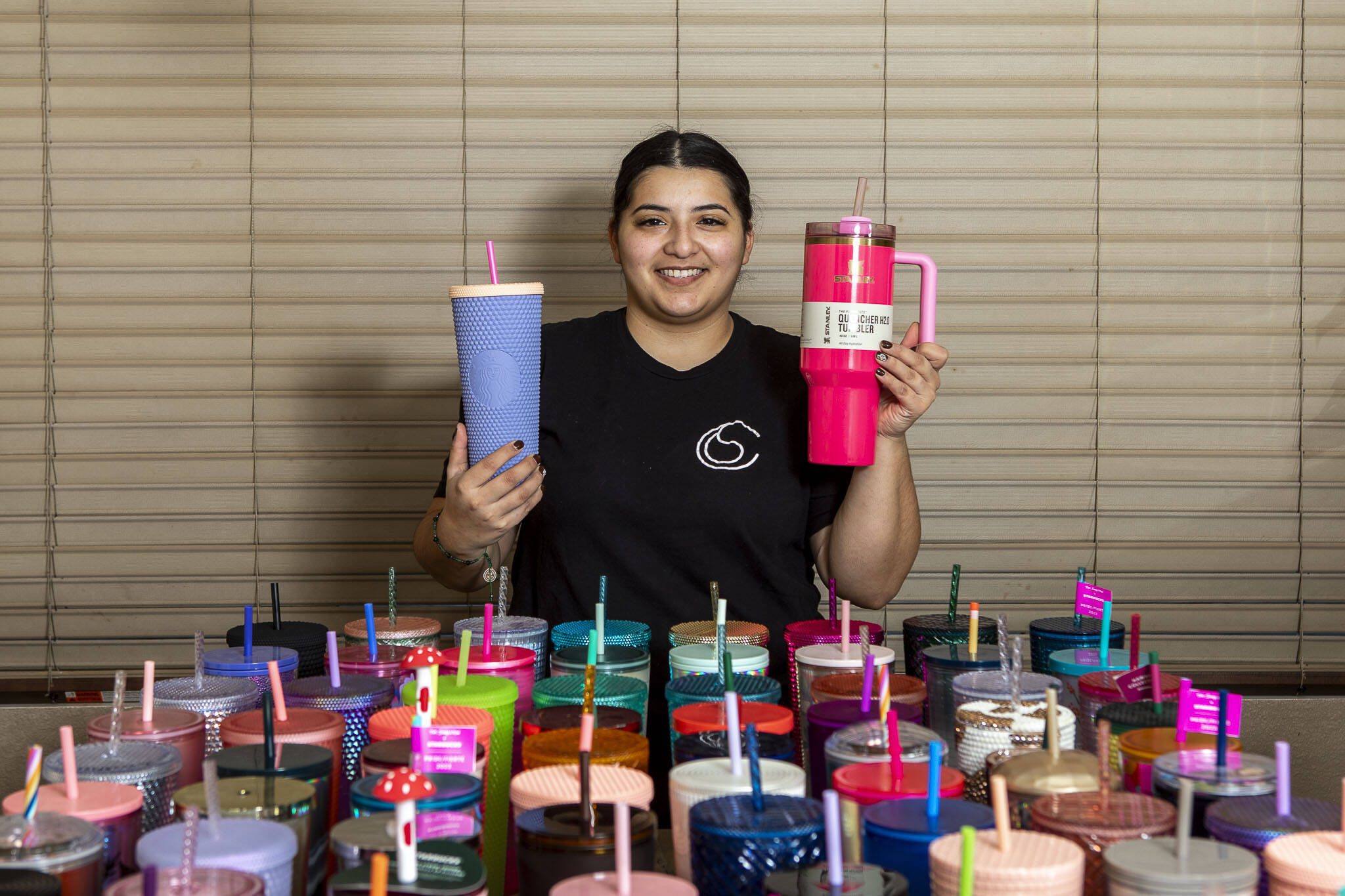 Cecilia Garcia, 26, poses with a portion of her water bottle collection at her home in Lake Stevens, Washington on Sunday, Jan. 14, 2024. (Annie Barker / The Herald)
