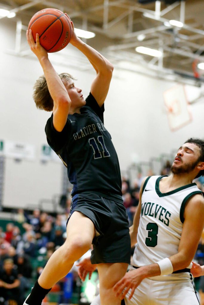 Glacier Peak’s Reed Nagel tries to get a twisting shot to fall against Jackson on Wednesday at Henry M. Jackson High School in Mill Creek. (Ryan Berry / The Herald)
