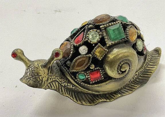 In real life, snails are unwelcome pests. But this one brings the shine of brass and colorful glass instead of leaving slime trails.
