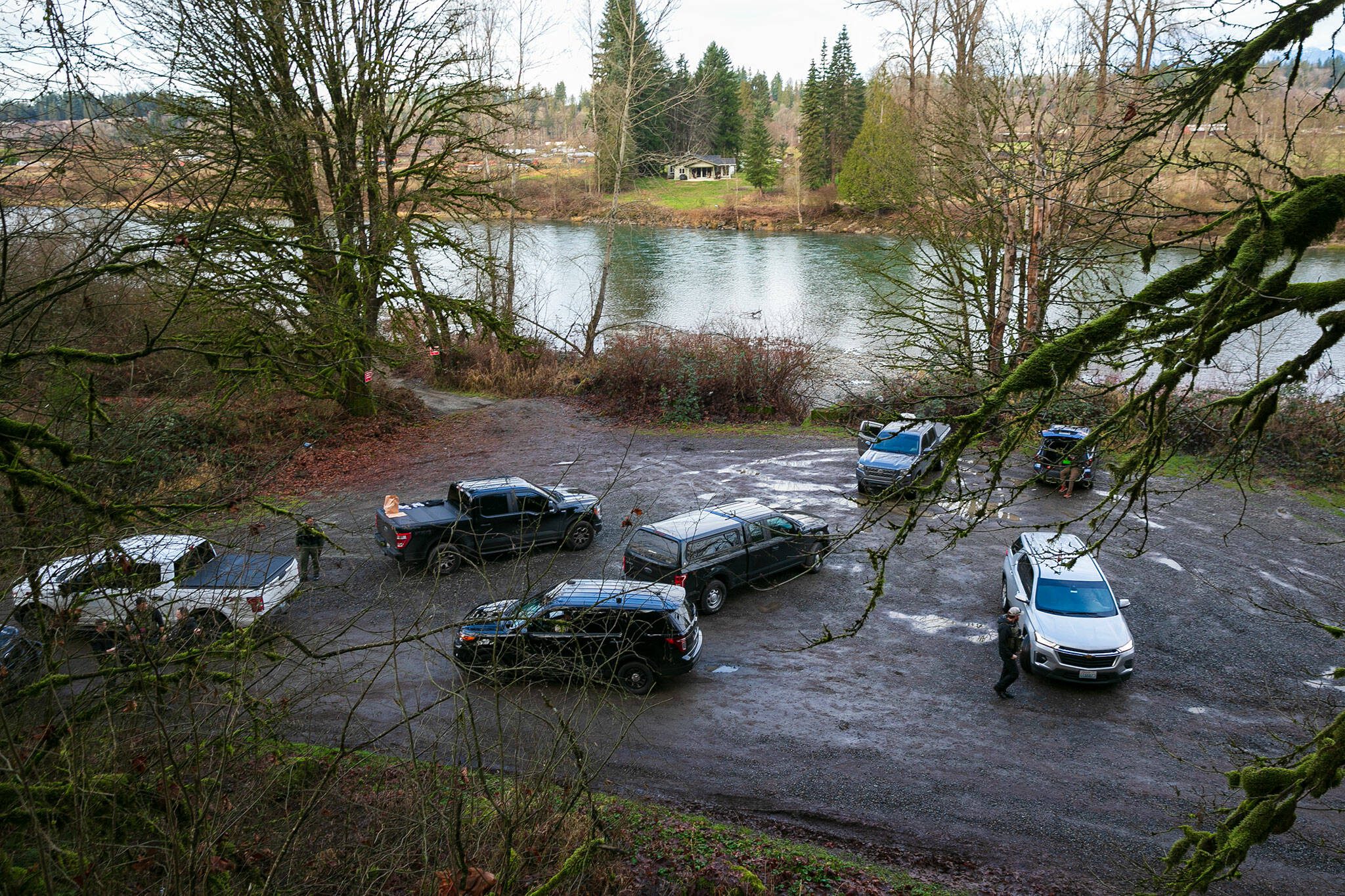 A large number off law enforcement are gathered at a Skykomish River water access on Ben Howard Road on Wednesday, Jan. 3, 2024, in Monroe, Washington. (Ryan Berry / The Herald)