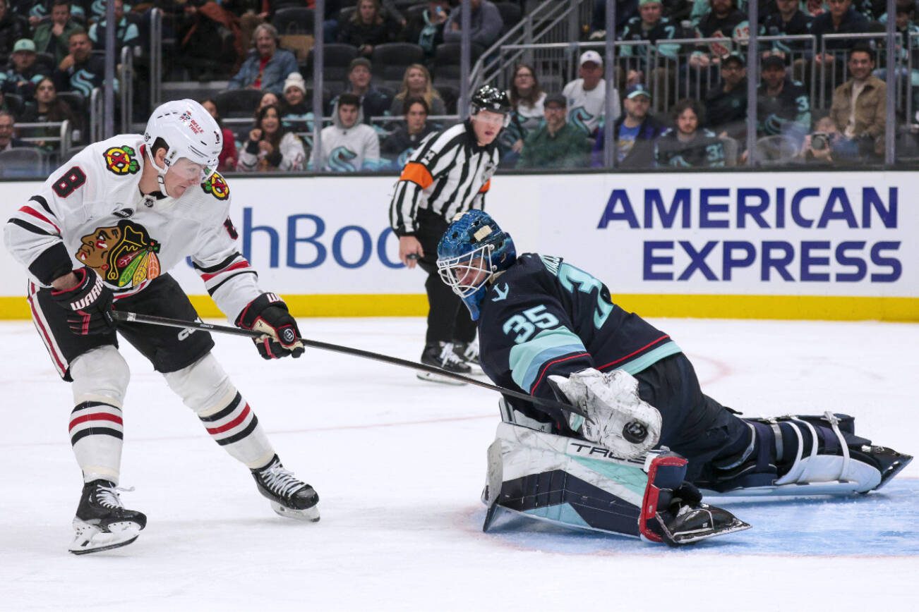 Seattle Kraken goaltender Joey Daccord (35) makes a save on a breakaway by Chicago Blackhawks center Ryan Donato (8) during the third period of an NHL hockey game Wednesday, Jan. 24, 2024, in Seattle. (AP Photo/Jason Redmond)