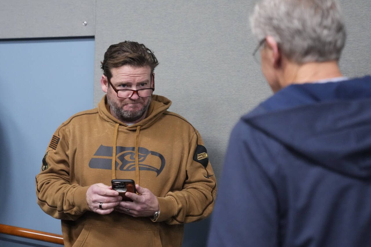 Seattle Seahawks general manager John Schneider looks over at former head coach Pete Carroll as he arrives during a media availability on Jan. 10 after it was announced Carroll will not return as head coach next season. (AP Photo/Lindsey Wasson)