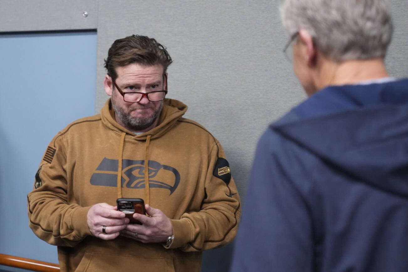 Seattle Seahawks general manager John Schneider, facing, looks over at head coach Pete Carroll as he arrives during a media availability after it was announced he will not return as head coach next season, Wednesday, Jan. 10, 2024, at the NFL football team's headquarters in Renton, Wash. Carroll will remain with the organization as an advisor. (AP Photo/Lindsey Wasson)