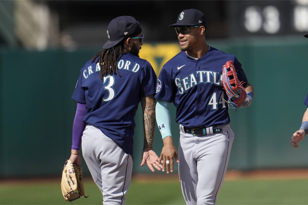 Seattle Mariners' J.P. Crawford (3) celebrates with Julio Rodriguez (44) after the Mariners defeated the Oakland Athletics in a baseball game in Oakland, Calif., Wednesday, Sept. 20, 2023. (AP Photo/Jeff Chiu)