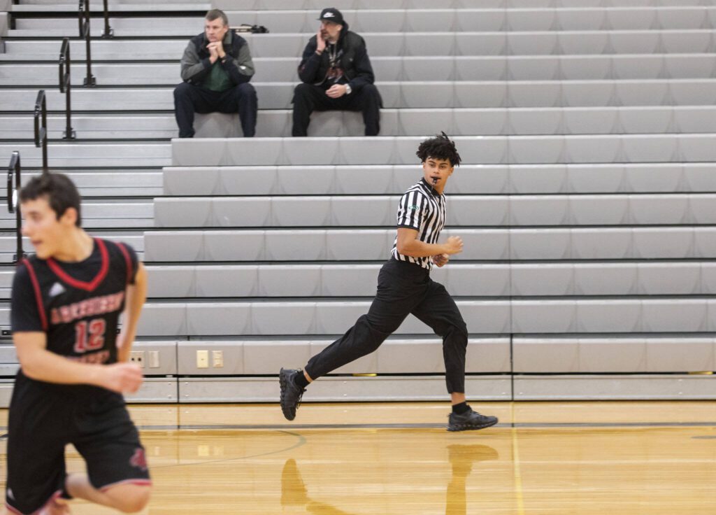 Chandler Hyde runs down a court while refereeing a game Jan. 16 at Lynnwood High School in Bothell. (Olivia Vanni / The Herald)
