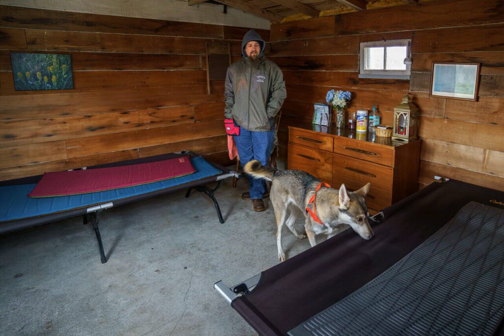 Josh Carr watches as Arda detects odor around a cot. (Photo by David Welton)
