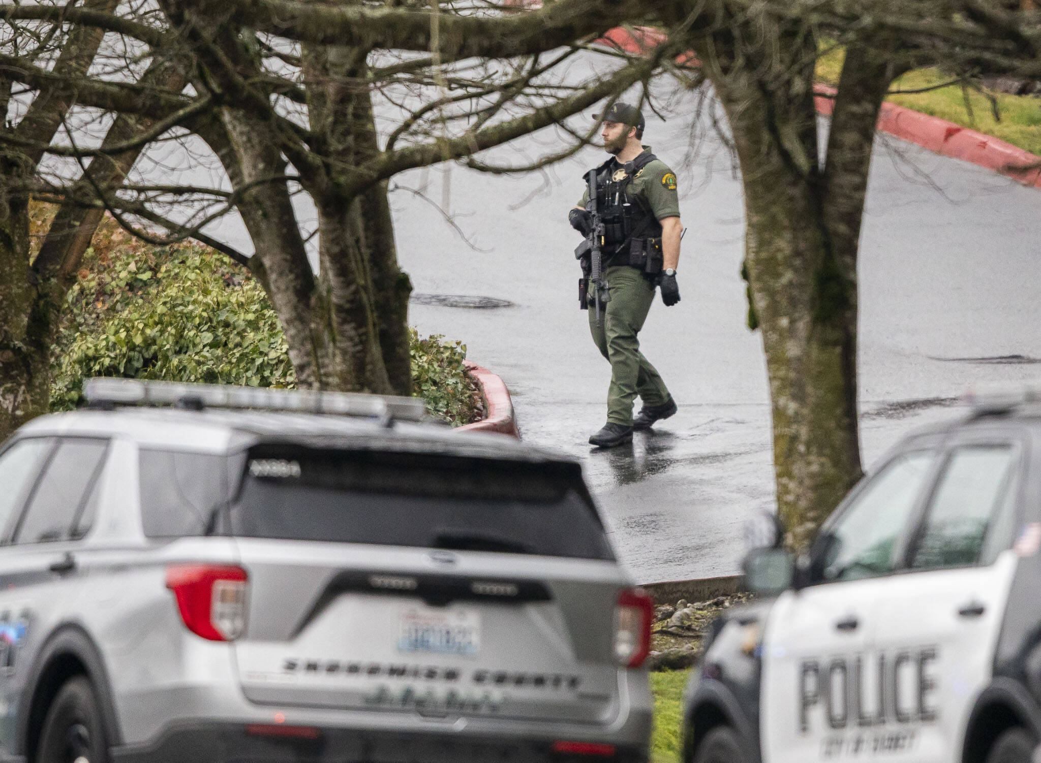 A Snohomish County sheriff’s deputy walks down a hill toward 112th Street SW on Wednesday, Jan. 31, 2024 in Everett, Washington. (Olivia Vanni / The Herald)