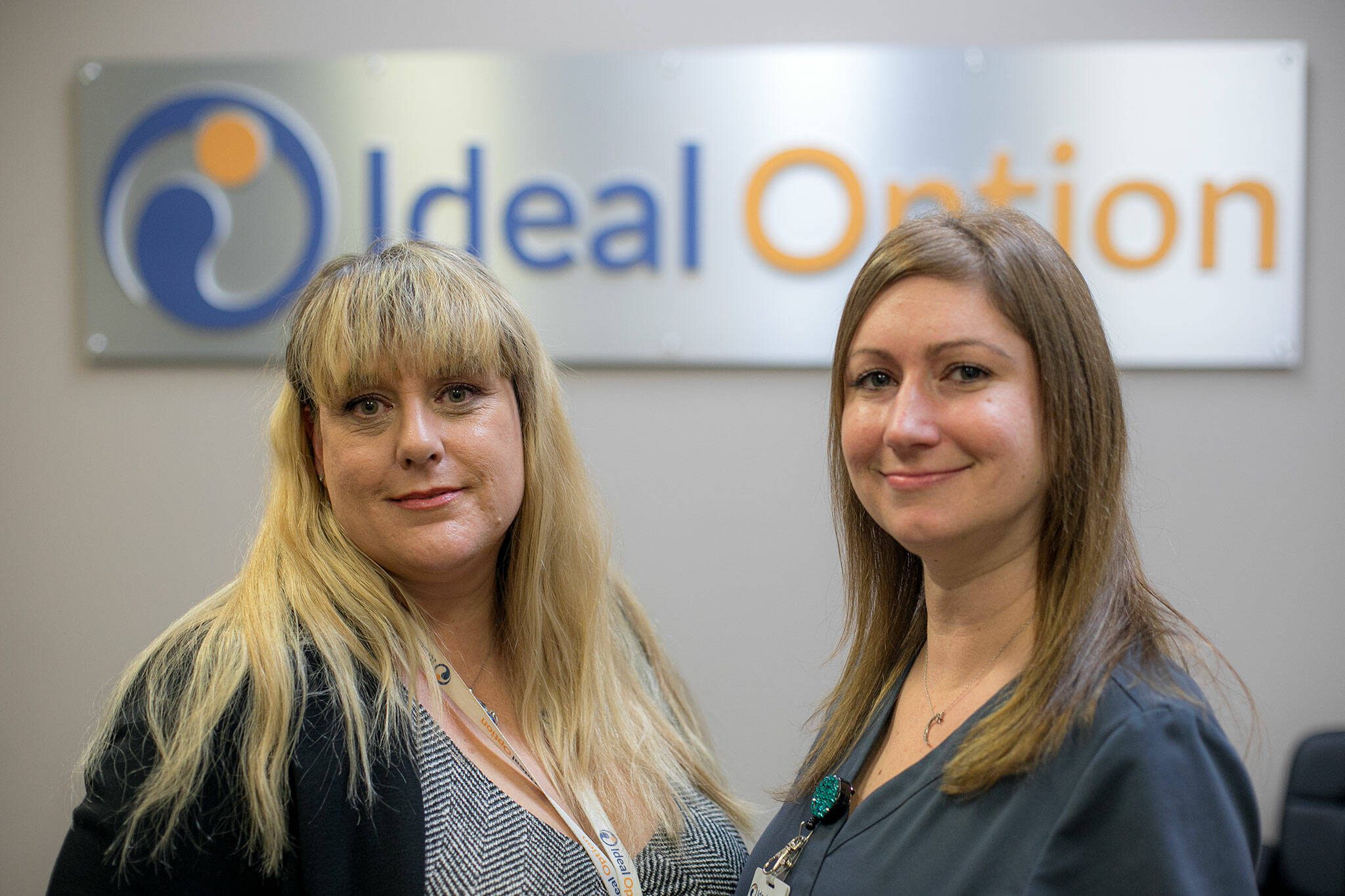 Community outreach coordinator April Provost and medical assistant Tricia King stand inside the new office space at Ideal Option on Wednesday, Jan. 3, 2024, in Monroe, Washington. (Ryan Berry / The Herald)