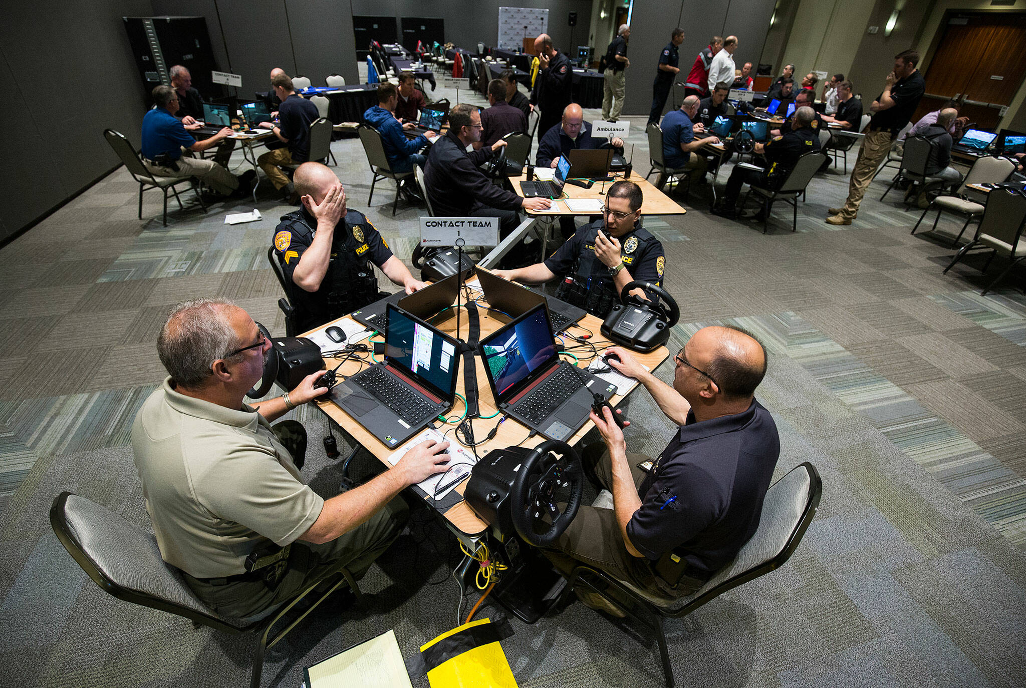 Law enforcement officers, firefighters and medics from Snohomish, King and Pierce counties use computers to simulate an active shooter scenario in a ballroom at Angel of the Winds Arena on Wednesday, June 13, 2018 in Everett, Wa. (Andy Bronson / The Herald)
