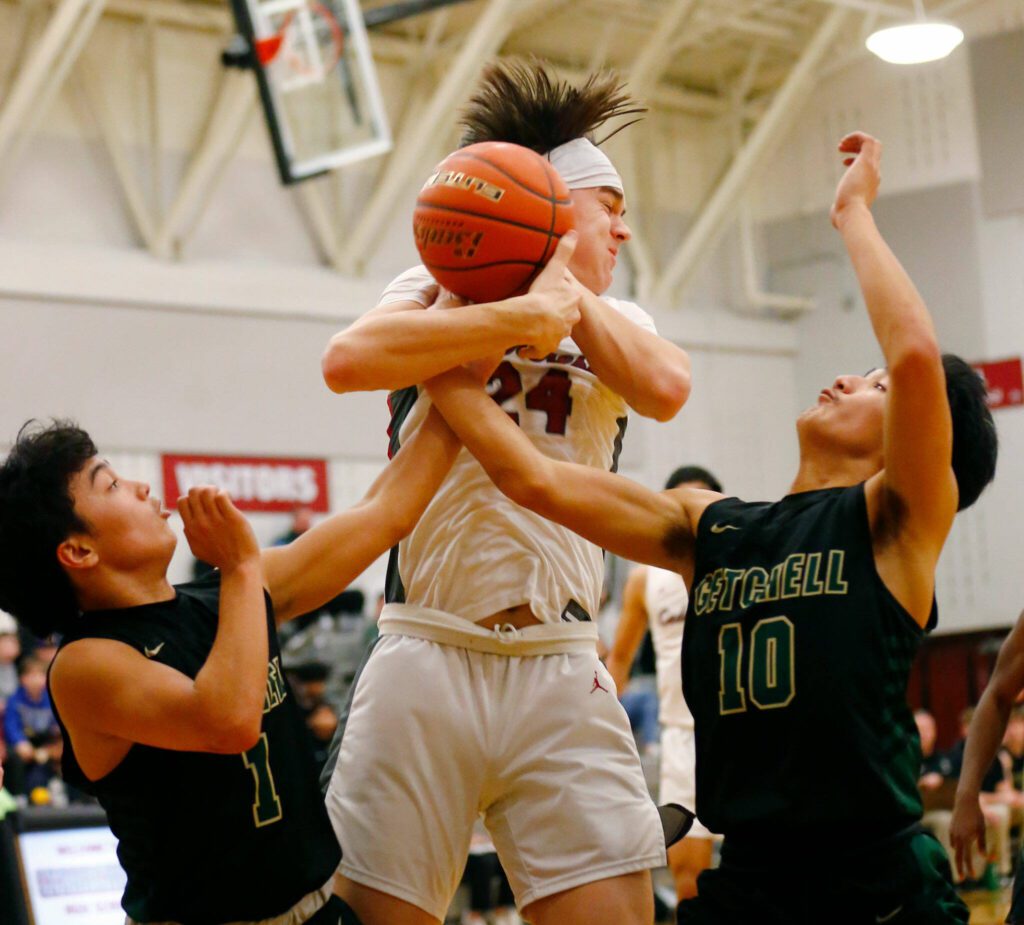 Marysville Getchell’s Ano Palacol, left, and Bubba Palacol, right, work together to knock free a loose ball against Cedarcrest on Jan. 16 at Cedarcrest High School in Duvall. (Ryan Berry / The Herald)
