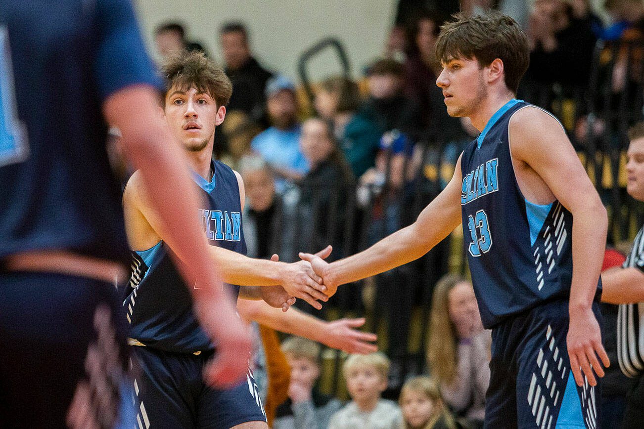 Toby Trichler, left, and brother Eli Trichler, right, high five after a blocked shot during the game against King's on Tuesday, Jan. 23, 2024 in Shoreline, Washington. (Olivia Vanni / The Herald)