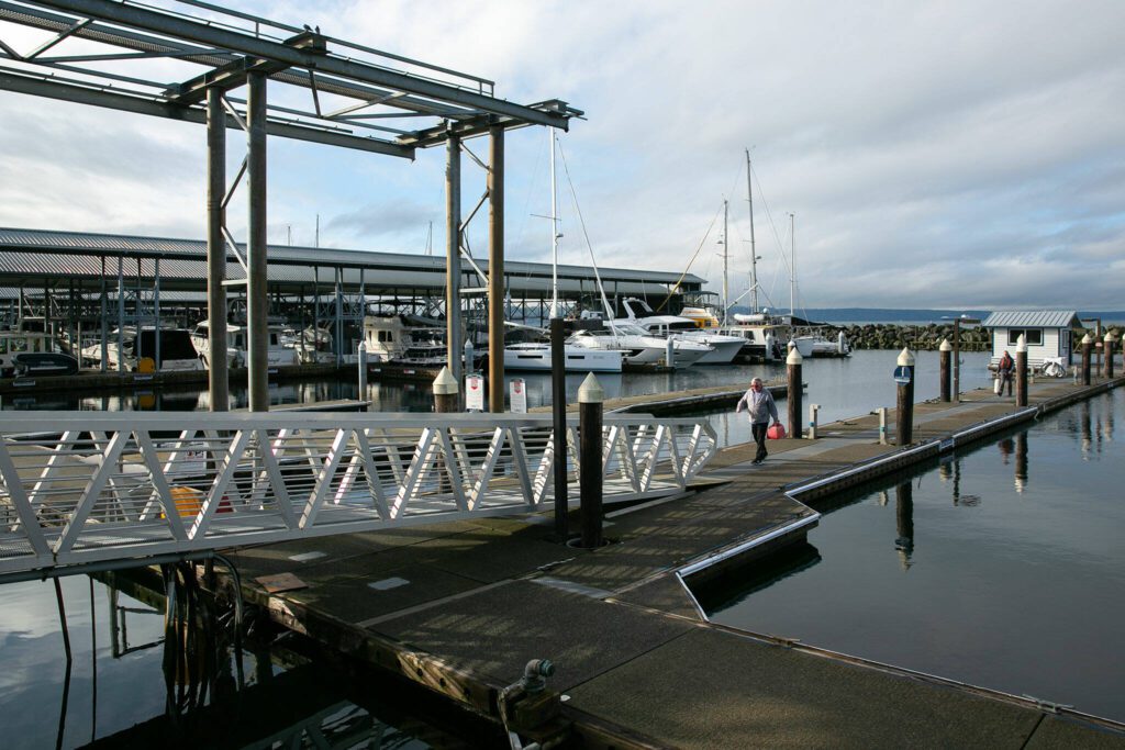 A man with a gas can walks back to shore at the Port of Edmonds on Wednesday, Jan. 24, 2024, in Edmonds, Washington. (Ryan Berry / The Herald)
