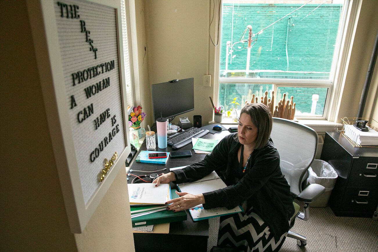 Jennifer Ross, a PCAP case manager, prepares for the day at her desk at Sound Pathways on Thursday, Jan. 25, 2024, in downtown Everett, Washington. (Ryan Berry / The Herald)