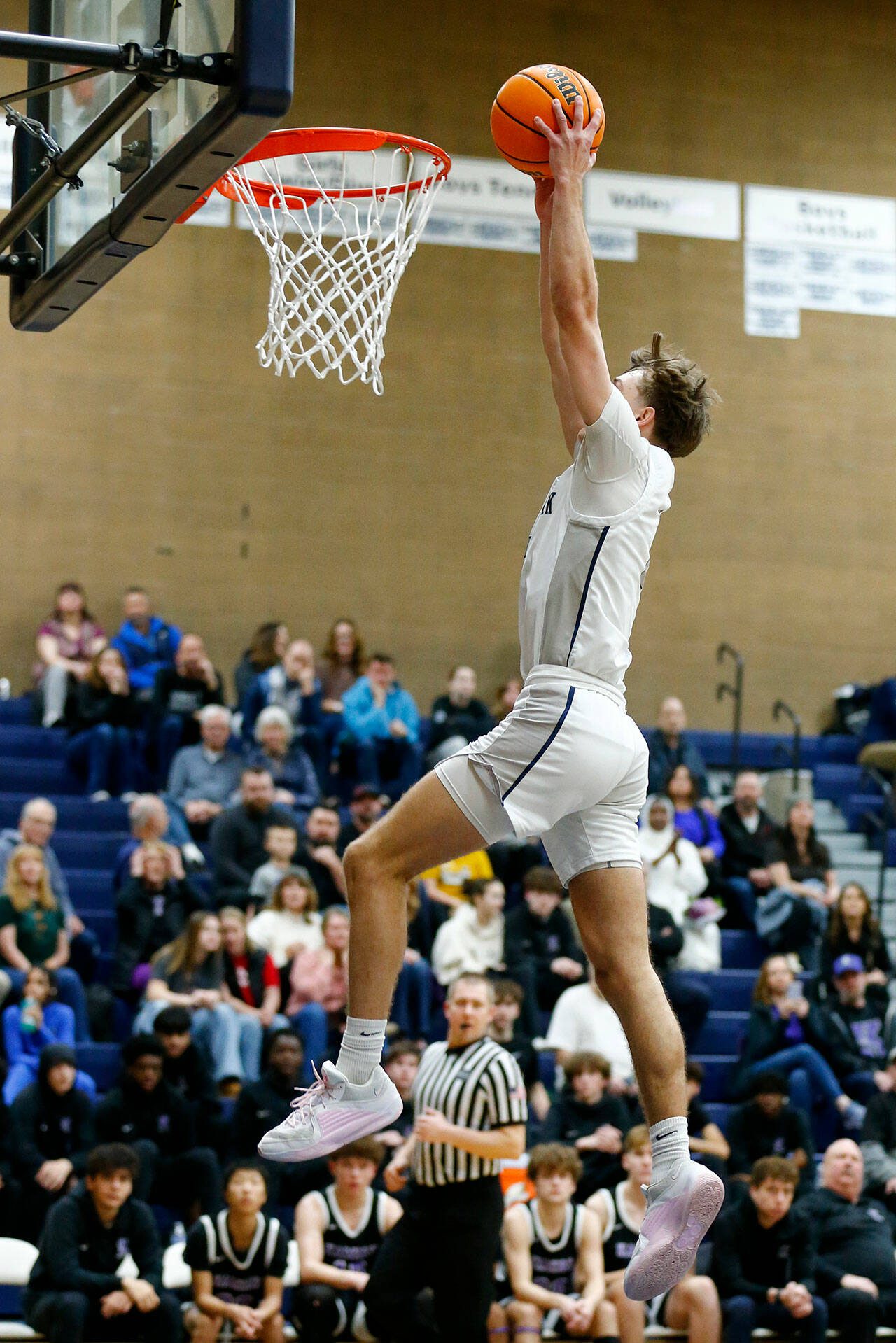 Glacier Peak junior wing Jo Lee takes flight and finishes a fast break with a slam dunk against Kamiak during a game Thursday at Glacier Peak High School in Snohomish. (Ryan Berry / The Herald)