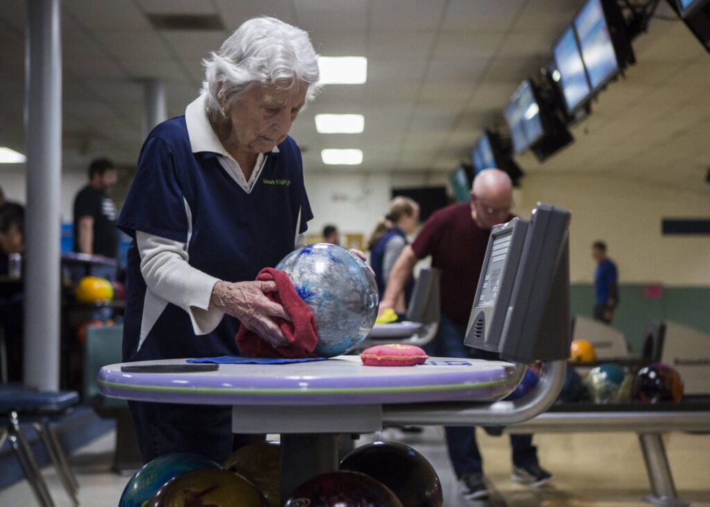 Carol Perry, 101, wipes her bowling ball before her turn to bowl during league bowling at Strawberry Lanes on Wednesday, Feb. 26, 2020 in Marysville , Wa. (Olivia Vanni / The Herald)
