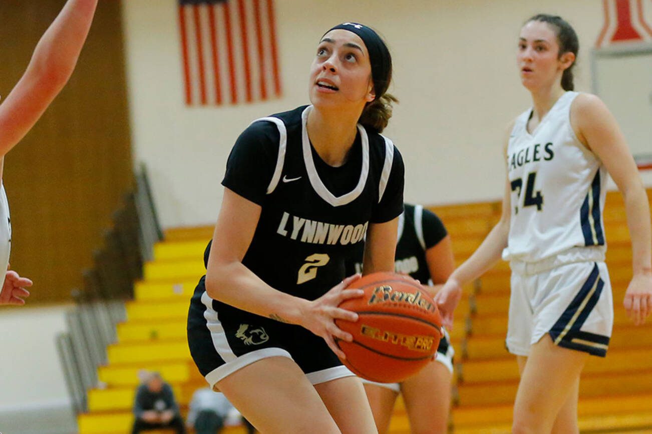 Arlington’s Kayla Lorenz turns to the basket before sinking a short shot against Lynnwood on Tuesday, Feb. 14, 2023, at Marysville Pilchuck High School in Marysville, Washington. (Ryan Berry / The Herald)