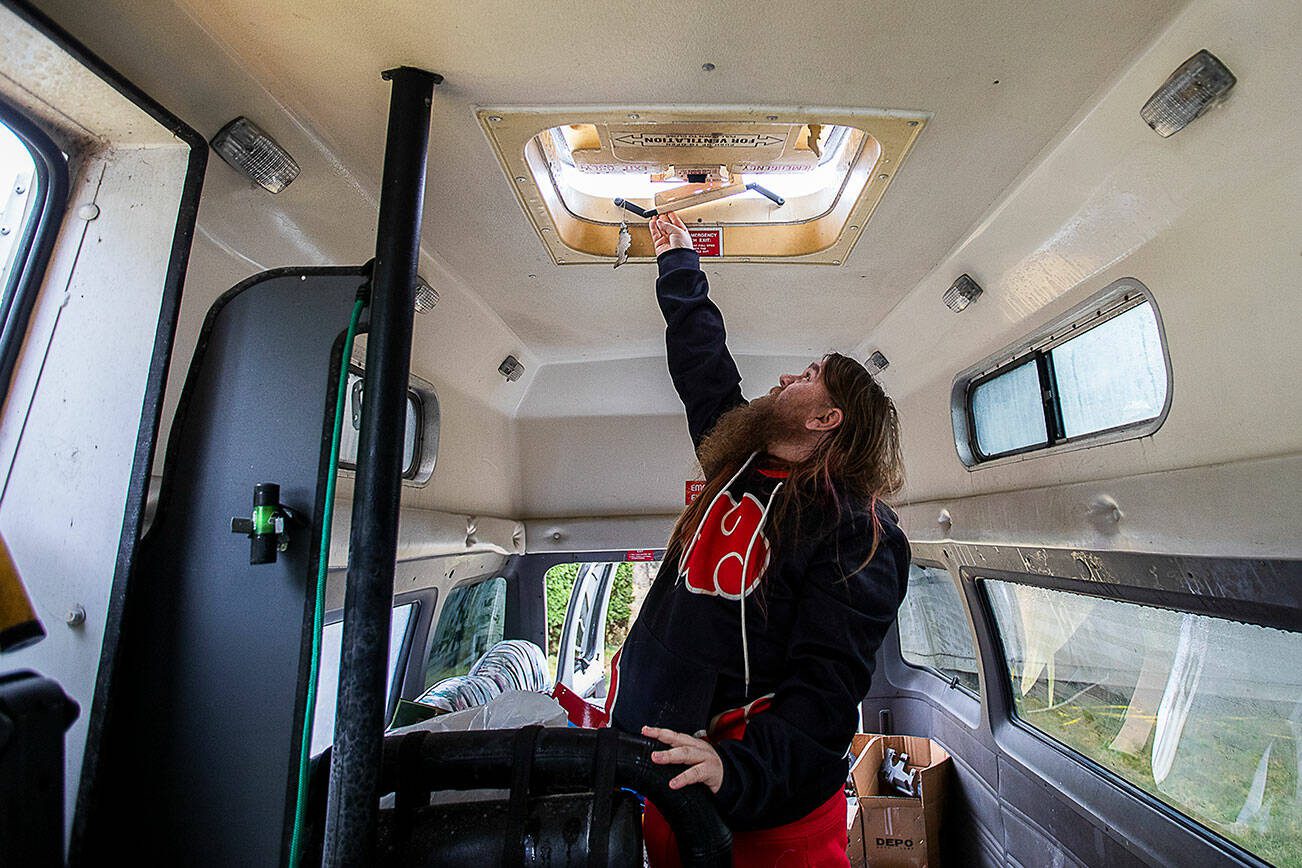 Johnson De Vor opens a ventilation latch at the top of the van on Monday, Feb. 5, 2024 in Granite Falls, Washington. (Olivia Vanni / The Herald)