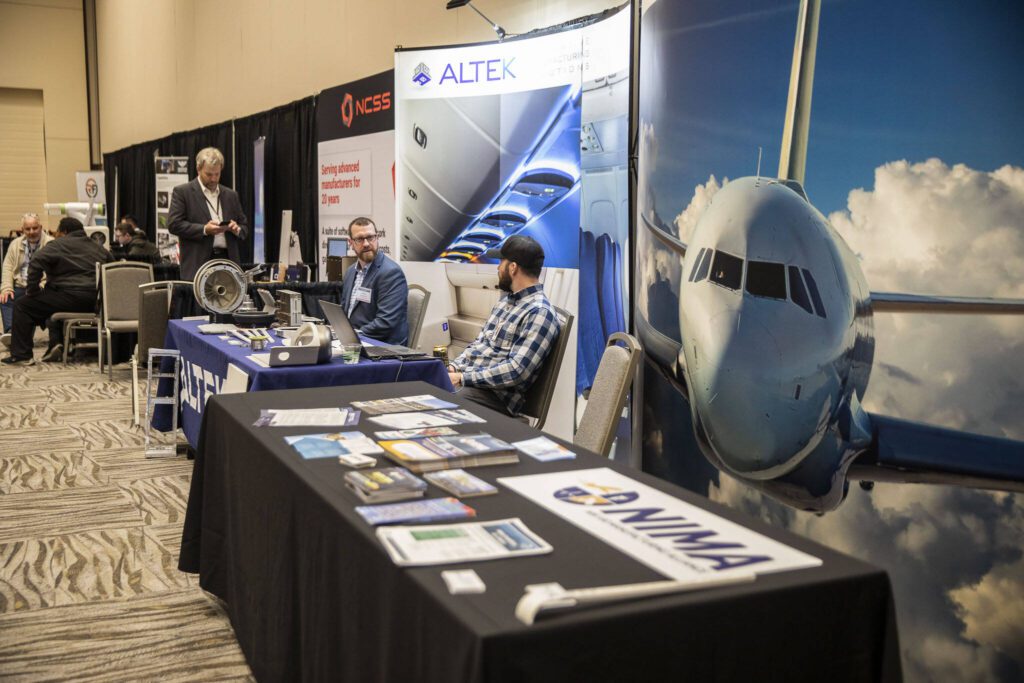 People sit at different booths set up at the Pacific Northwest Aerospace Conference on Wednesday, Feb. 7, 2024 in Lynnwood, Washington. (Olivia Vanni / The Herald)
