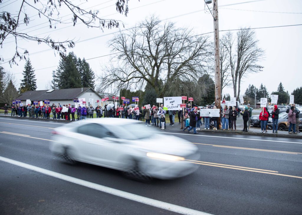 A car drives by a rally outside of the Marysville School Board on Monday, Feb. 5, 2024 in Marysville, Washington. (Olivia Vanni / The Herald)
