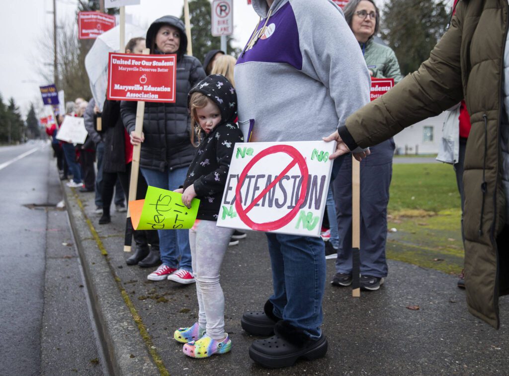 Emily Lynn, 5, looks at a no extension sign during a rally outside of the Marysville School Board on Monday, Feb. 5, 2024 in Marysville, Washington. (Olivia Vanni / The Herald)
