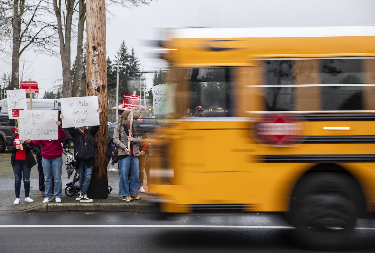 A school bus drives by rally before a Marysville School Board meeting on Monday, Feb. 5, 2024 in Marysville, Washington. (Olivia Vanni / The Herald)